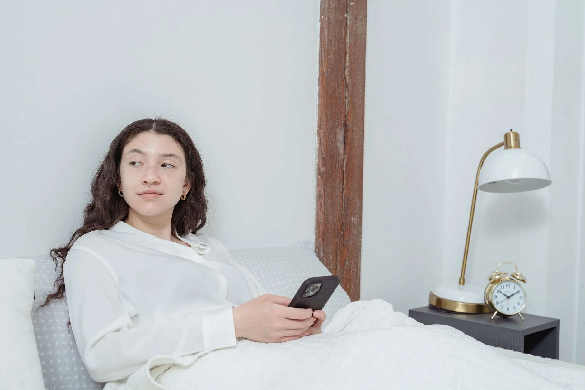 Femme découvrant l'heure miroir 11h11 sur l'écran de son téléphone et s'interrogeant sur sa signification