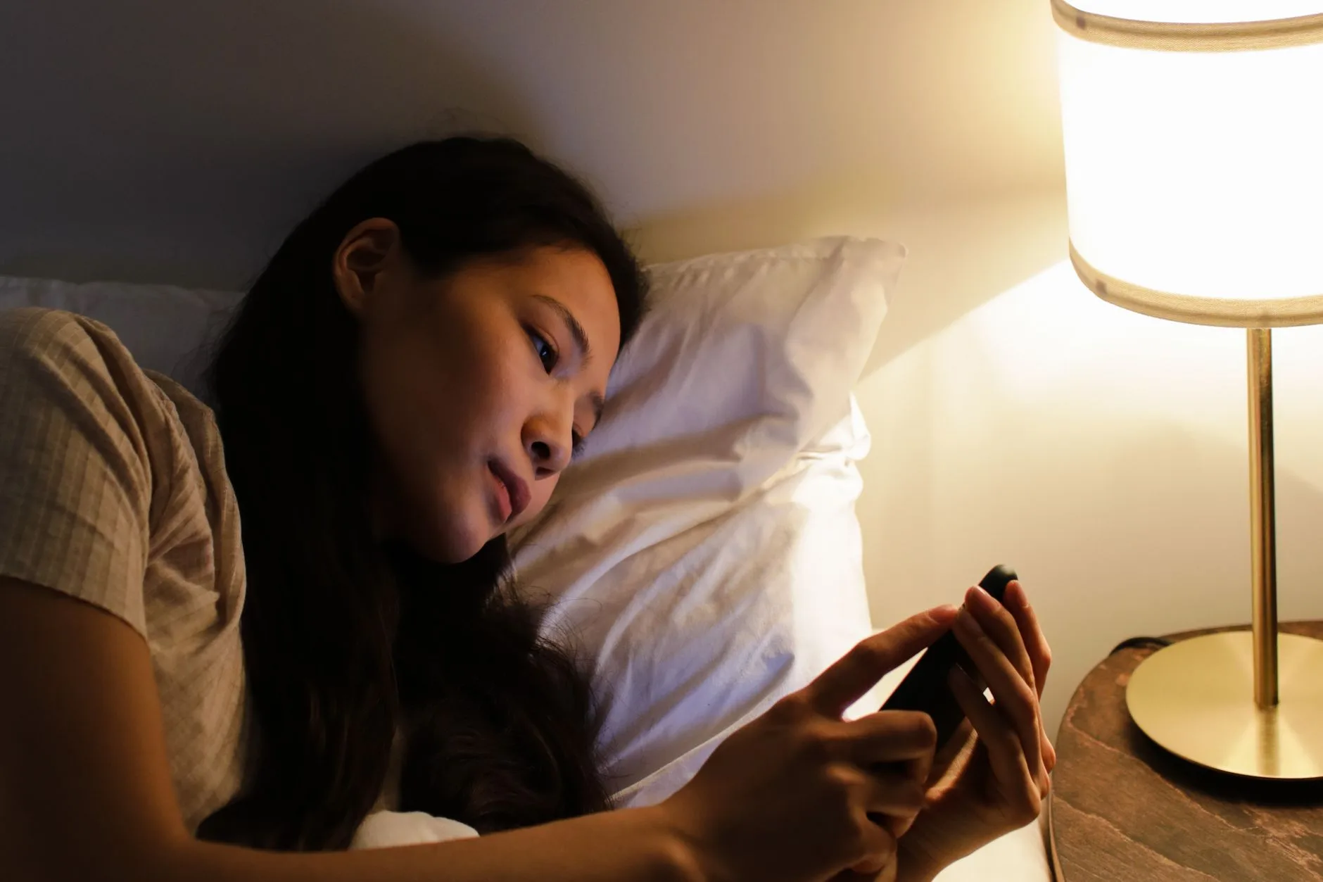 Femme découvrant l'heure miroir 12h12 sur son téléphone et s'interrogeant sur sa signification