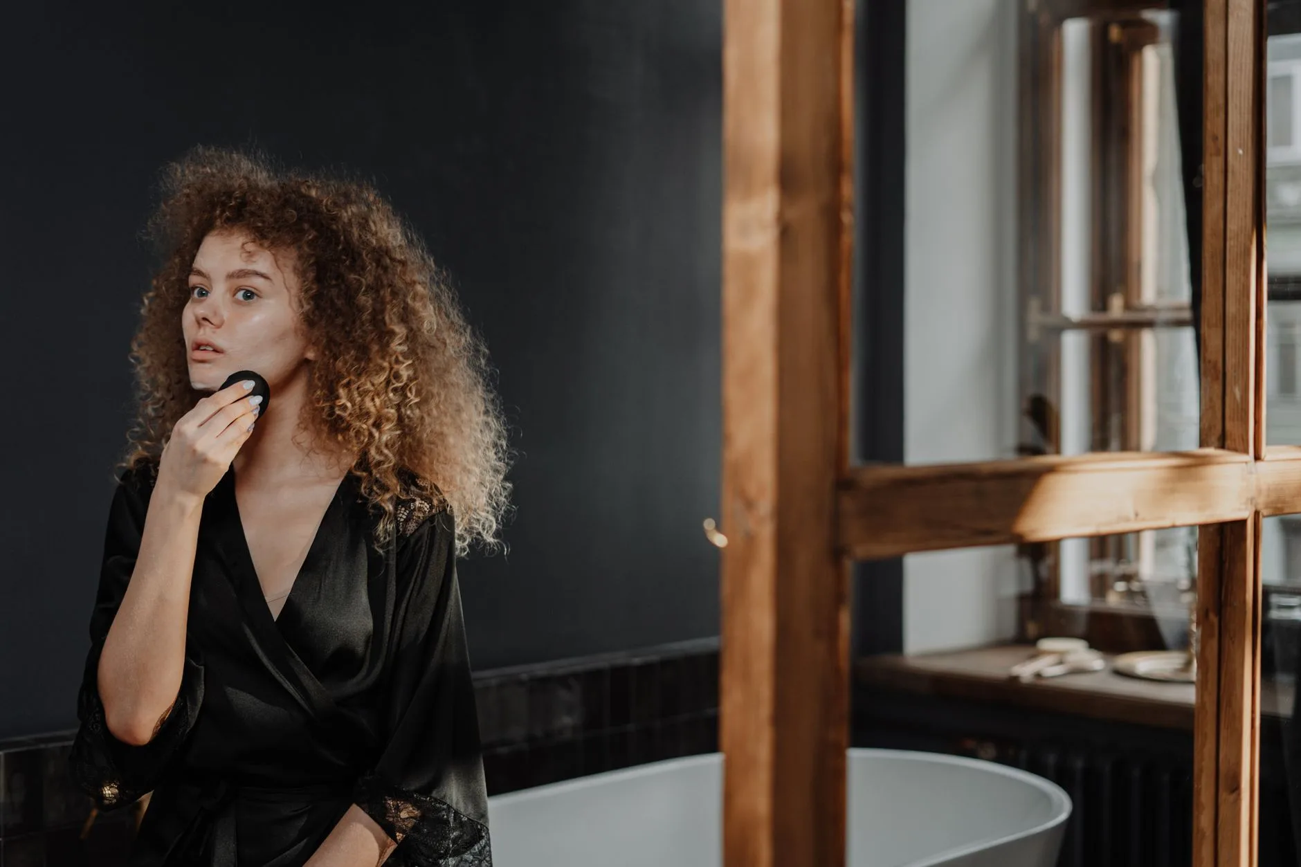 Femme appliquant sa routine méthode curly sur cheveux bouclés pour des boucles définies